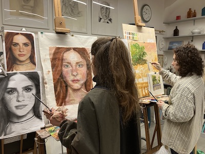 Due allieve del corso di pittura dipingono ad olio al cavalletto
